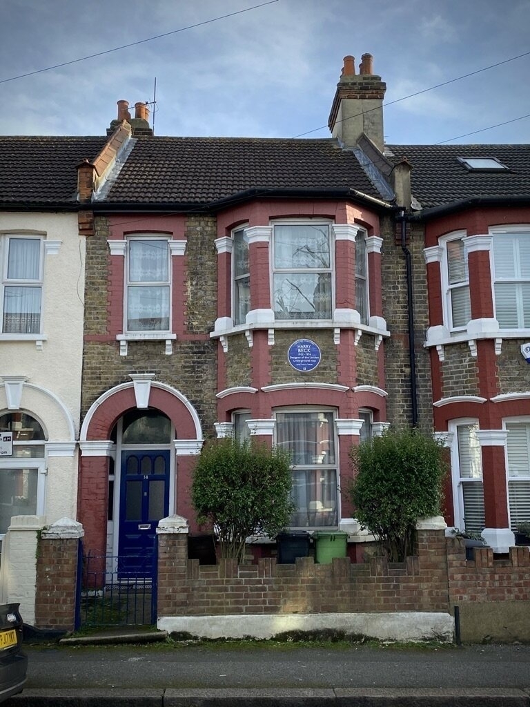 A photo of a terraced house. It has a blue plaque.